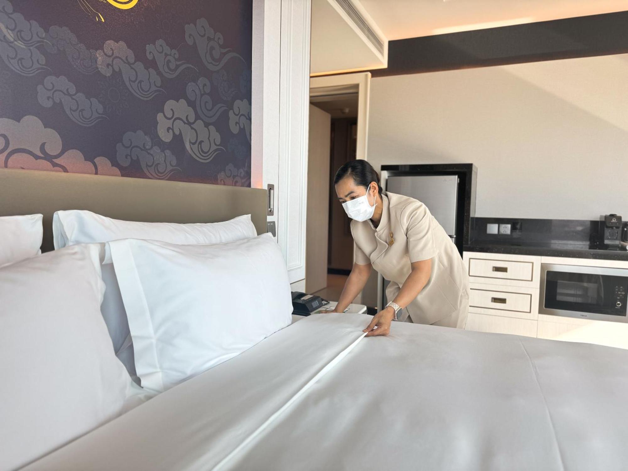 Grande Centre Point Surawong Bangkok Hotel Exterior photo A housekeeper making a bed at a hotel